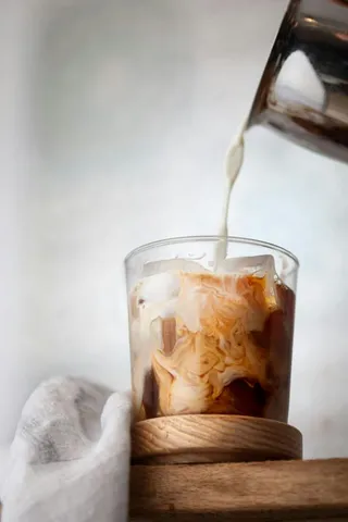 Milk poured into iced coffee